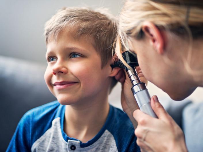 A doctor examining a child's ear.