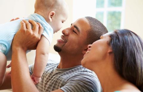 mom and dad smiling at baby