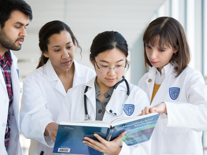 Students looking at a medical textbook 
