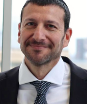 Headshot of Dr. Stelzer in white dress shirt and black tie and jacket