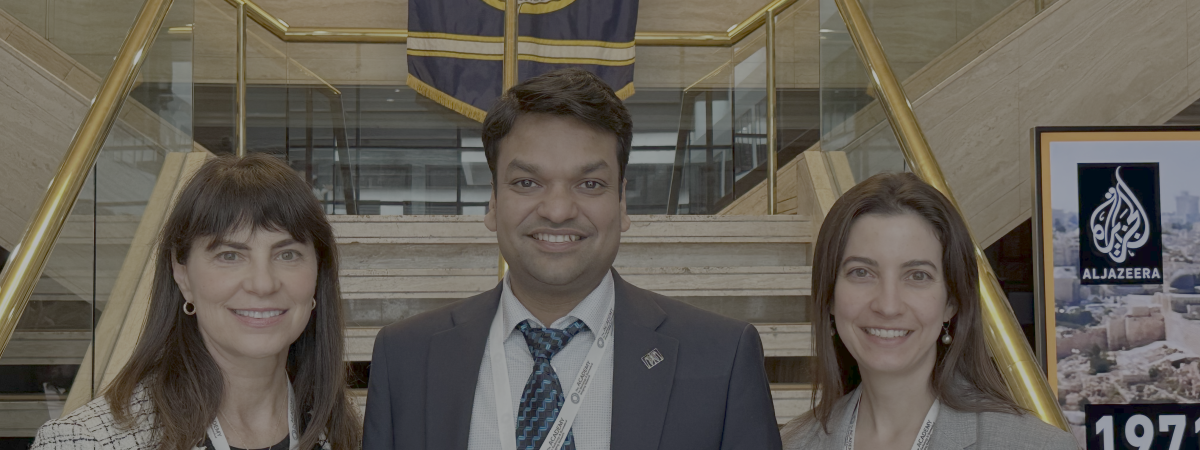 three people in business attire in front of a National Press Club sign