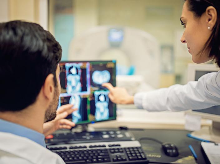Doctors are working with CT scan in hospital