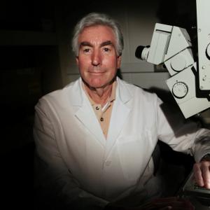 Jerry Silver posing for a photo beside some lab equipment.