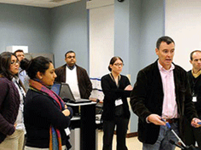 A man giving a demonstration to a group of onlookers