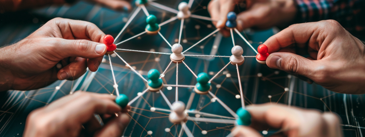 Hand connecting figures with twine 