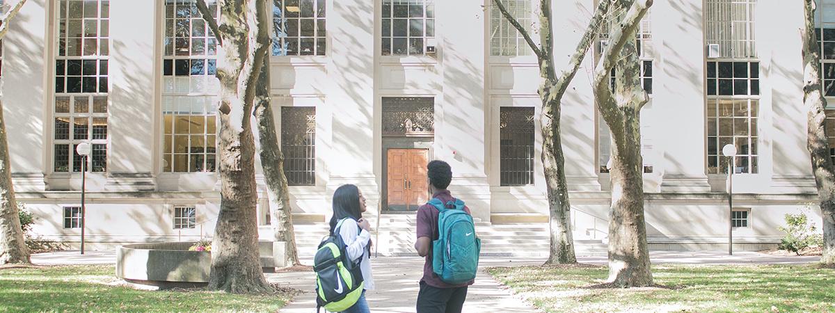 Two students walking into a school building