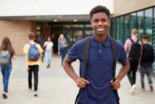 young african american male smiling with peers at school