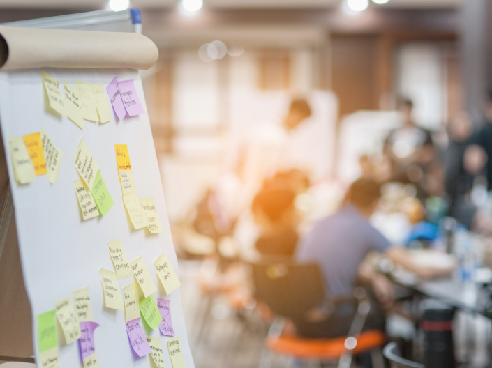 Message board with out of focus meeting behind the board 