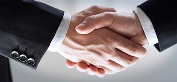 Picture of close up of the hands of two professionals in suits shaking each others hands