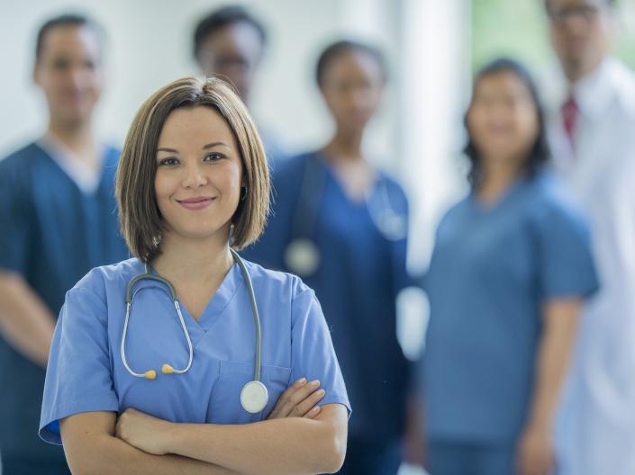 Image of woman and group of medicine professionals behind her