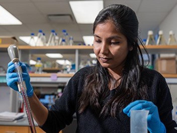 A female MSTP student working in a lab.