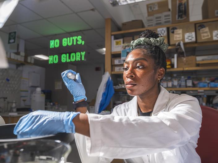 A woman in a lab coat works in the Institute for Glial Sciences laboratory