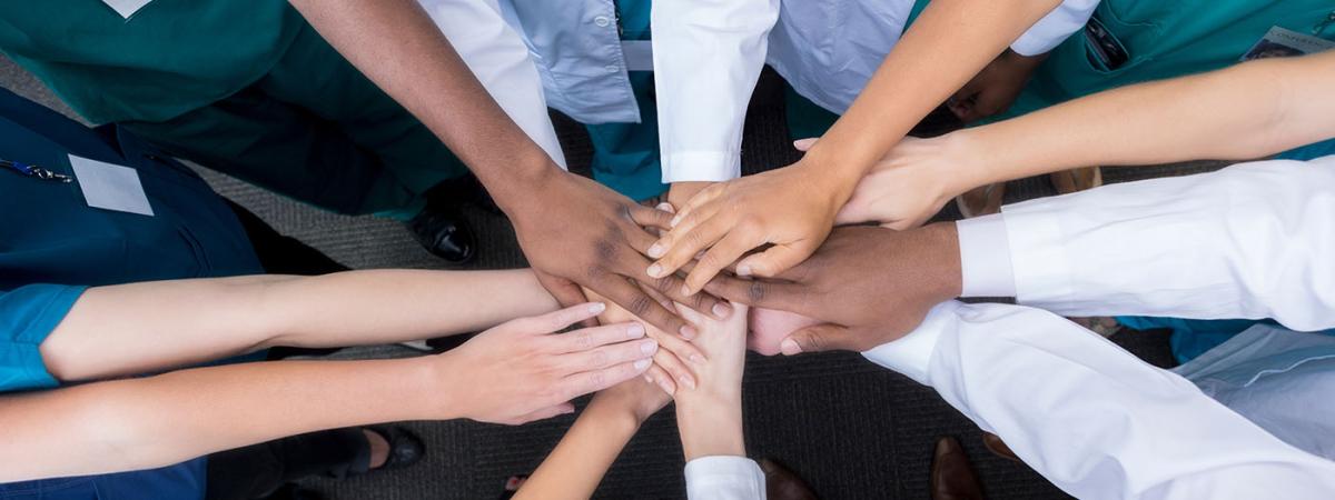 Close up of a group of medical students with their hands together.