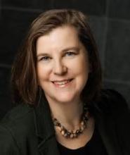 Woman with medium dark hair and a necklace