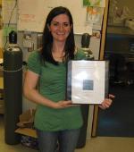 Gina holding a plaque.