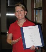 Melissa holding a paper smiling.