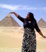 Sylvia with her hand on a pyramid.