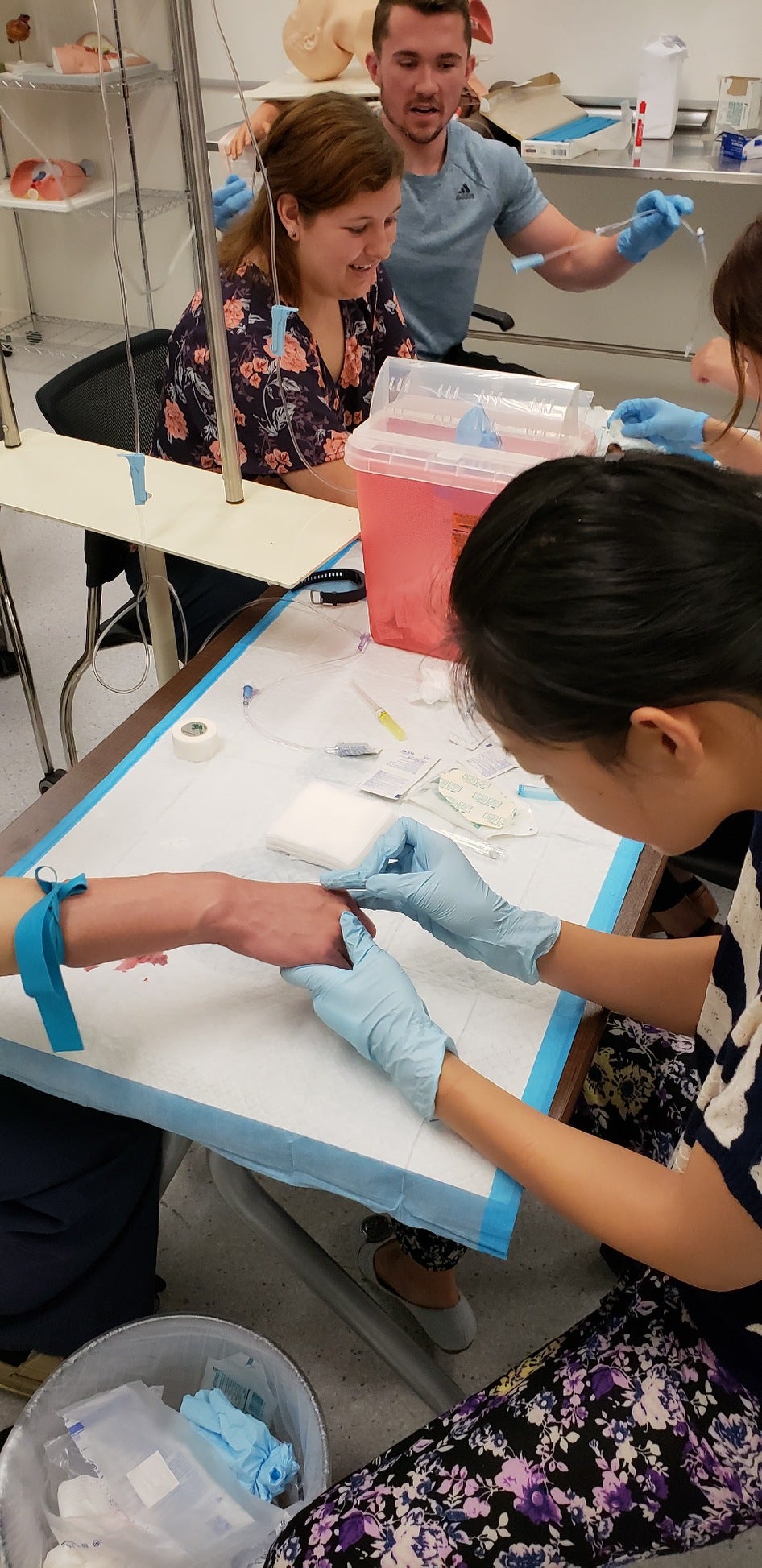 CWRU MSA student placing IV in hand with two students in background