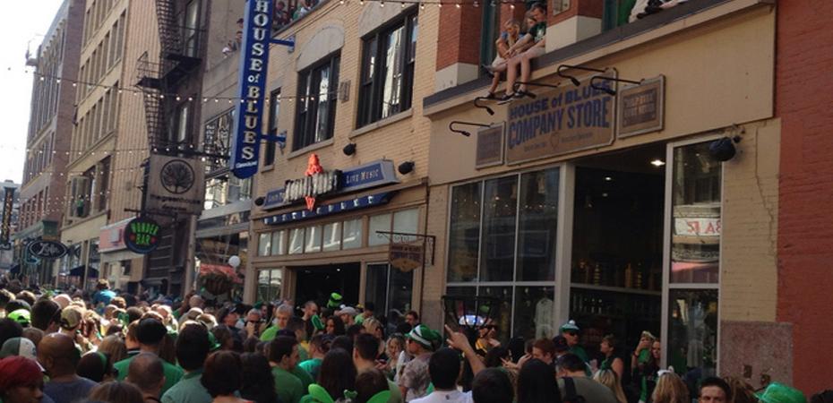 Image of crowd during Saint Patrick's Day in downtown Cleveland with House of Blues sign in the right midground and House of Blues Company Store sign in the right foreground