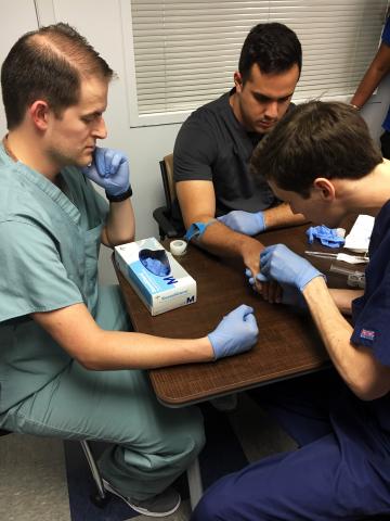 One student practices IV on volunteer while instructor observes