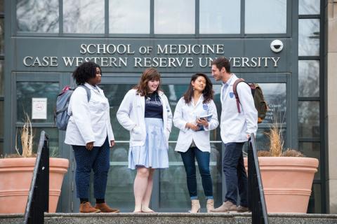 Three female students and one male student standing in front of Case Western Reserve University School of Medicine doorway