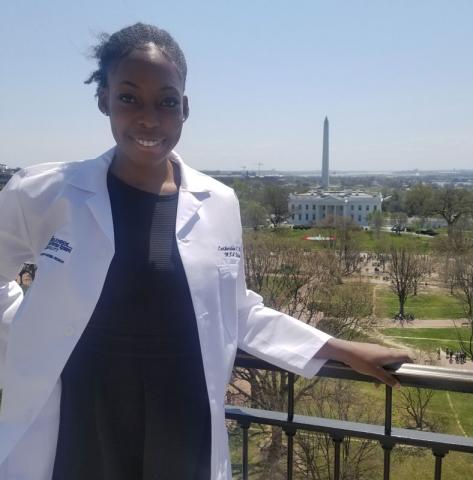 Female certified anesthesiologist assistant in white coat standing in front of Washington monument