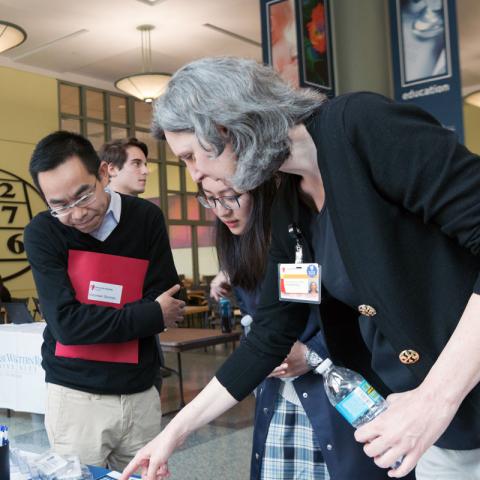 Female admissions director pointing at materials in front of two students