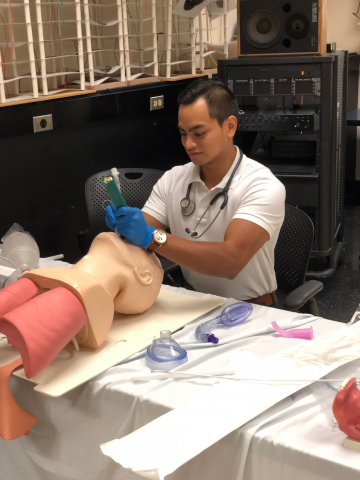 Student working on intubating task trainer