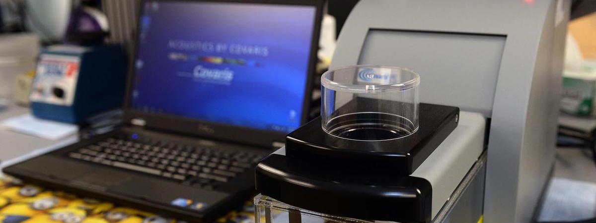 A laptop sits next to lab equipment ready to begin analysis.