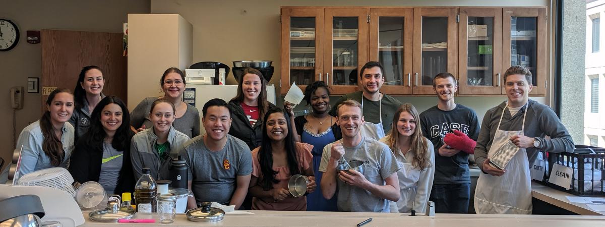 A group of Physician Assistant Program students pose in a teaching kitchen.
