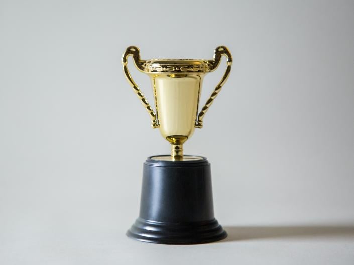 A gold-colored trophy with a black base on a white background.