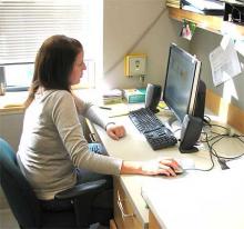 Female seated at a desk working on a desktop computer