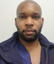 An african american man with a beard and blue jacket.
