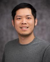 Headshot of Zhemin Zhang in a grey shirt with a blurred grey background
