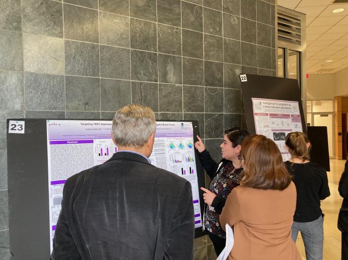 Students and faculty discussing poster presentations at the Pharm 22 Retreat
