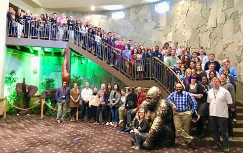 Department of pharmacology faculty and staff standing on staircase for group photo at annual retreat