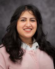 Headshot of Rana Abdelgawad with a pink sweater and grey blurred background