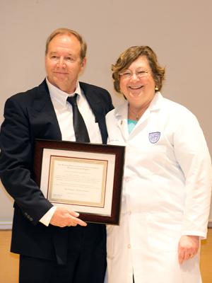 Image of Mr. Hudson standing with Dean Davis accepting the certificate.