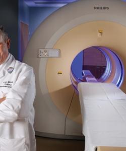Pablo Ros, MD, MPH, PhD in front of CT scanner 