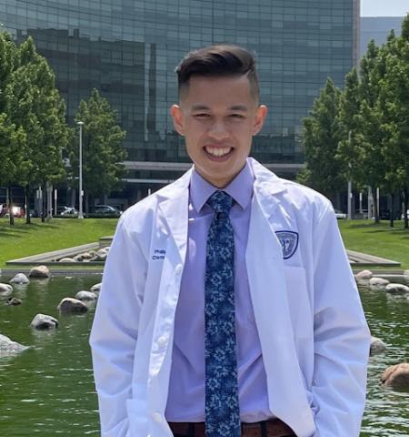 Phillip Bounkeua in a whitecoat in front of hospital