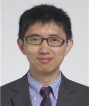 Portrait of Feixiong Cheng wearing blue dress shirt, dark suit jacket and tie.