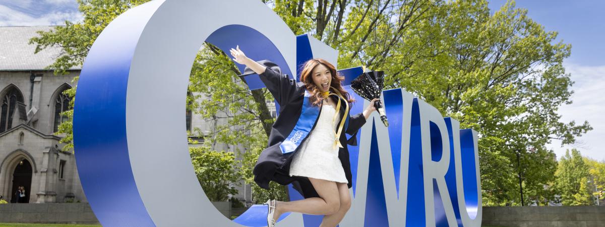 Student jumping in from of CWRU sign