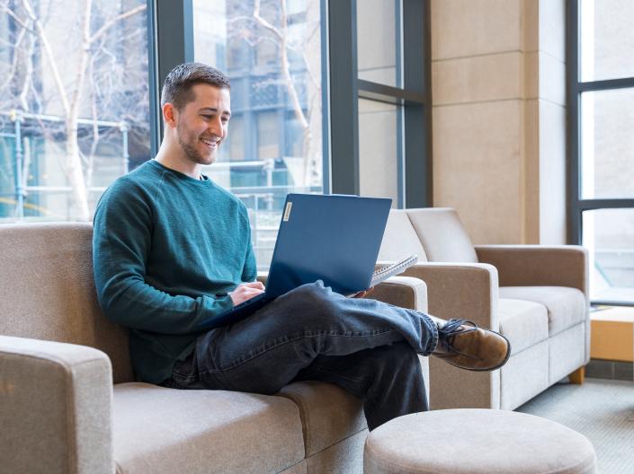 Student smiling at computer