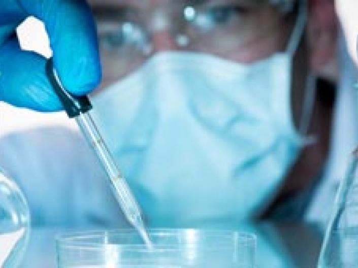 Laboratory Assistant or Researcher with Glass Beakers, Flasks and Bottles
