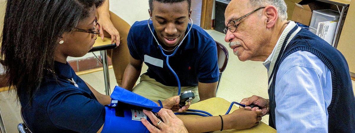 Two students learning how to take a blood pressure reading. 