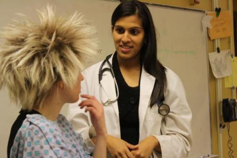 Asha Talati, Case Western Reserve University School of Medicine alumna, leads a class of high school students through a mock patient interview.