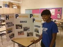 Taylor Moore, H3P alumna, prepares to present information on the club at an open house event.