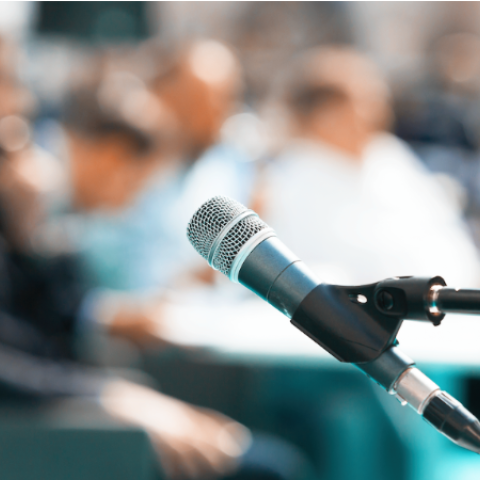 Blurred photo of microphone and people