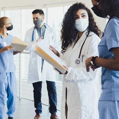 stock image of masked healthcare workers talking