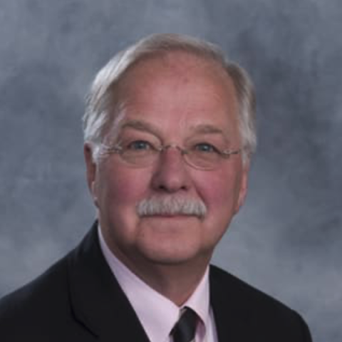 Dr. Cebul headshot wearing a tie and a pink dress shirt